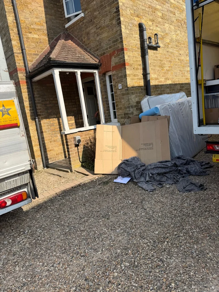 Wrapped mattress and moving blankets on the driveway during a house removal