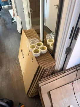Flat-packed moving boxes and rolls of packing tape supplied by SJC Movers
