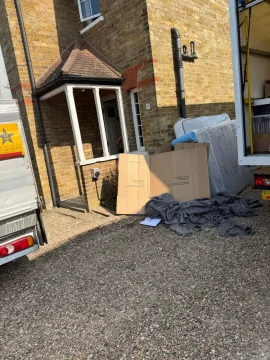 Wrapped mattress and moving blankets on the driveway during a house removal