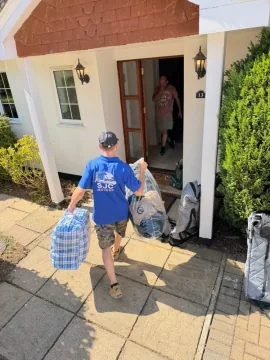 SJC mover carrying bags to the customer's front door on moving day