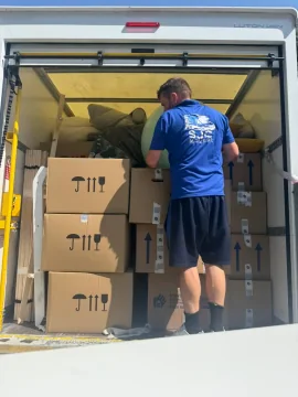 SJC mover stacking fragile-marked boxes neatly inside the removals van
