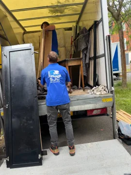 SJC mover loading a wardrobe onto the tail lift of the removals van