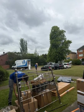 SJC Movers team loading a bed frame and boxes with the van waiting nearby