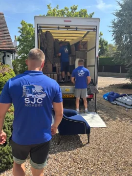 SJC Movers team carrying an armchair to the van during a house move