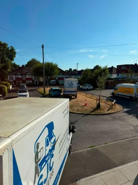 Two SJC Movers removals vans working a job on a residential street