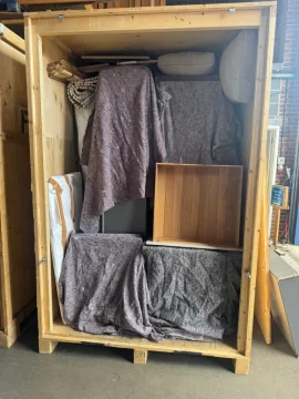 Timber storage crate packed with blanket-wrapped furniture at the warehouse