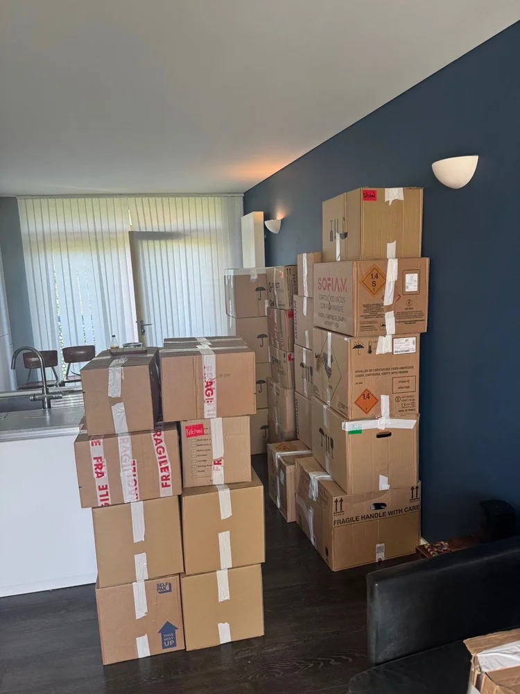 Boxes marked fragile packed in an open-plan living room ready to move