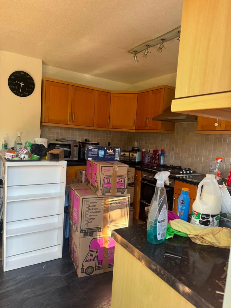 Moving boxes packed and stacked in a kitchen ready for collection