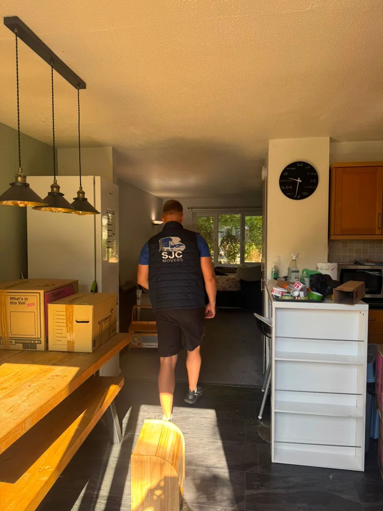 SJC mover carrying belongings through the house out to the van